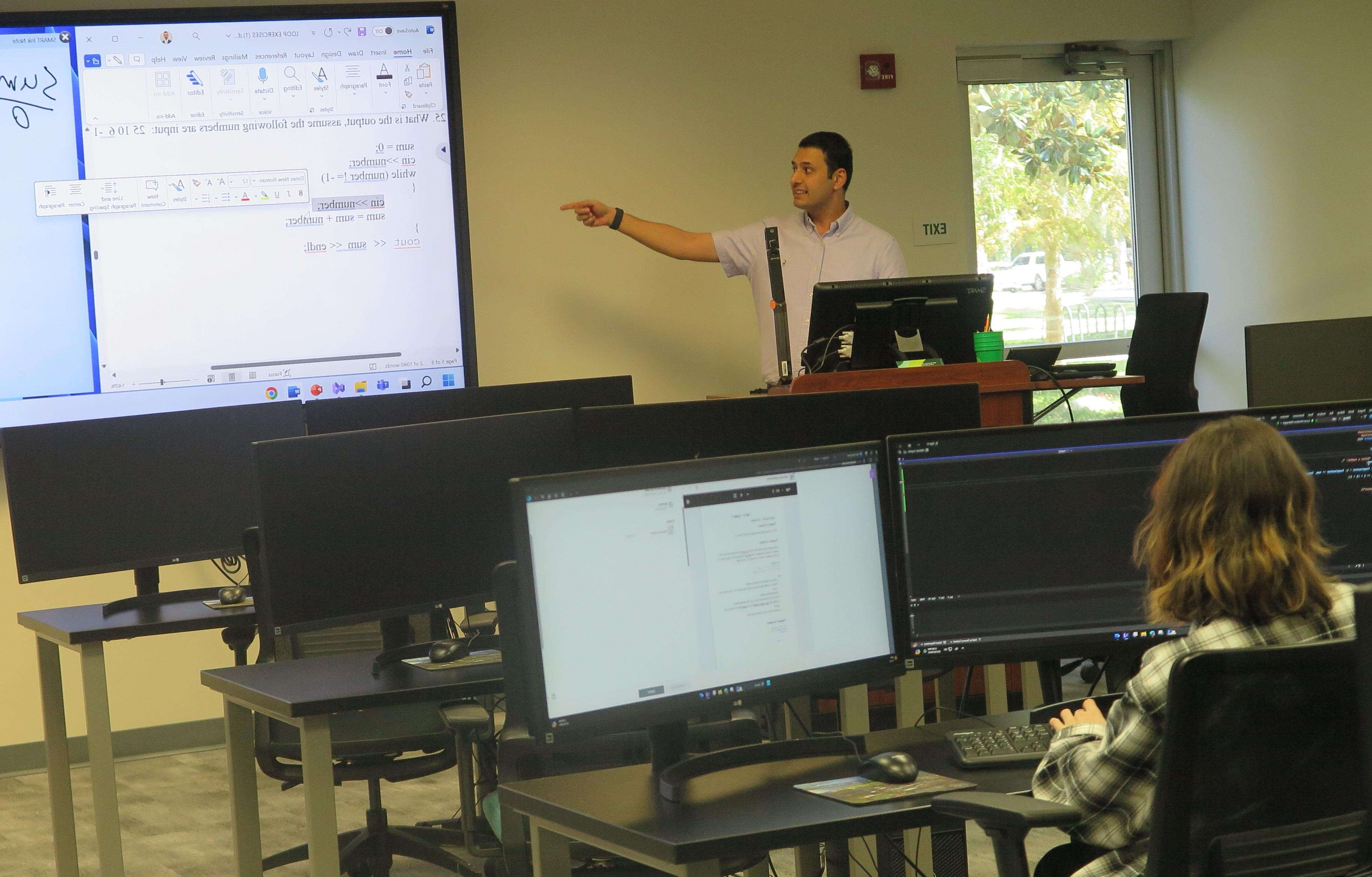 Student listening to the professor in a computer class.