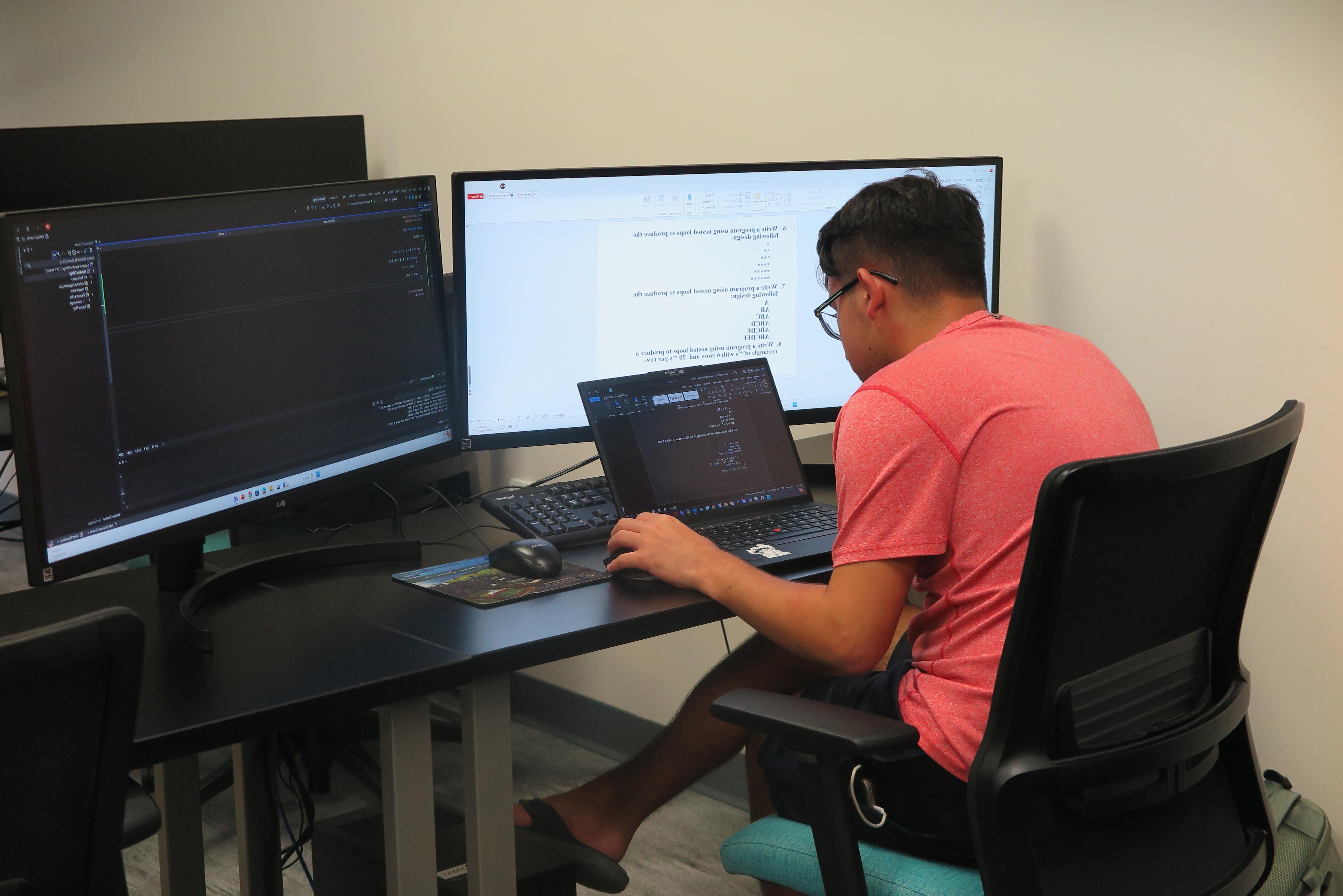 Professor teaching student in a computer class.